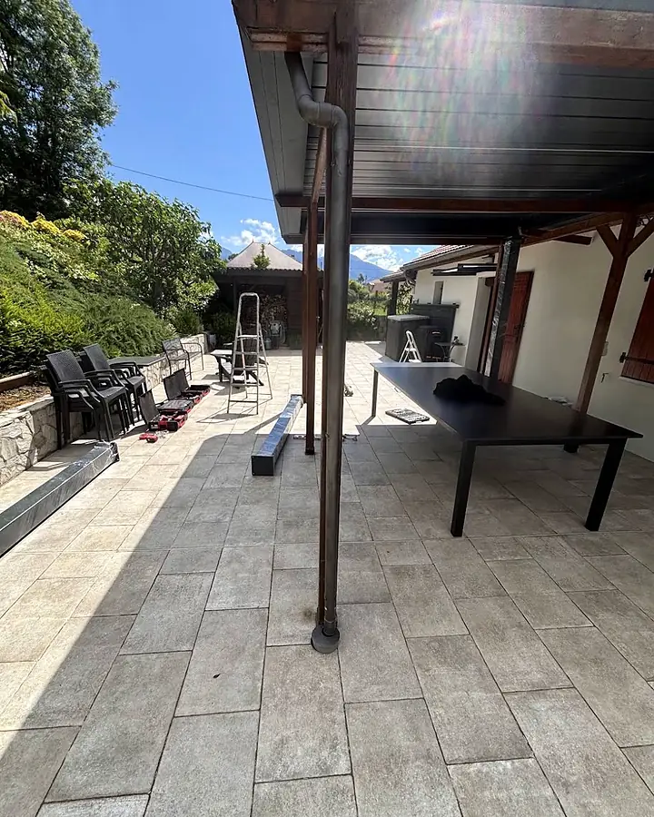 Nouvelle structure en place, descente d'eau le long du poteau. Auvent de terrasse, chantier de Trois Massifs Toiture.